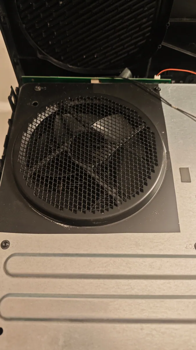 Xbox One opened up after cleaning, with clean mesh above the fan and a clean vent grille in the top cover